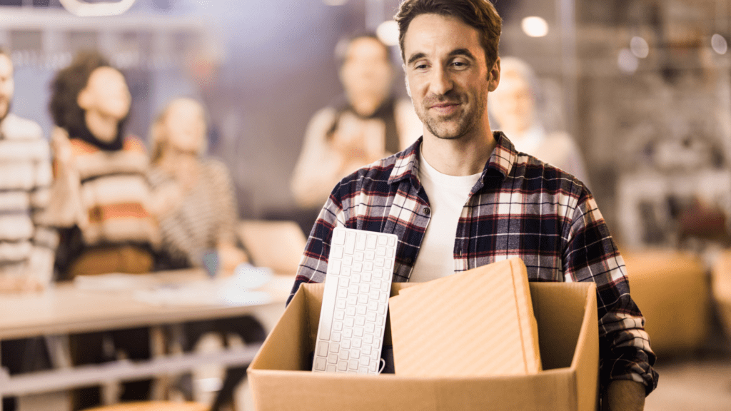 Male employee leaves office with packed box