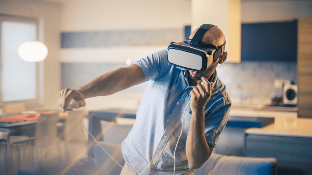 Man enjoying VR experience - wearing VR headset and using hand controllers