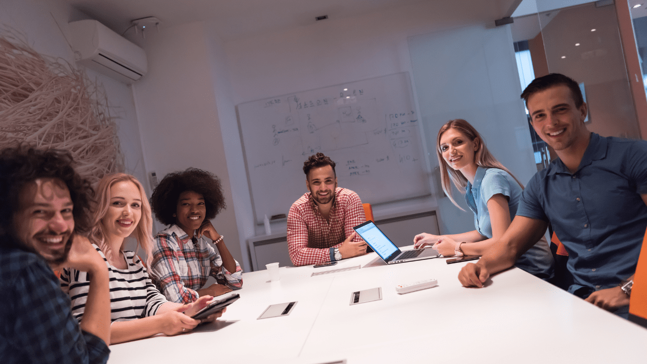 Diverse team of young, creative professionals in a modern meeting room.