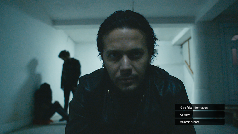 Still image from interactive Hostile Environment Awareness Training course available on Resilience Academy. Image shows a closeup of a man with three button options on screen: Give false information, Comply, Maintain silence