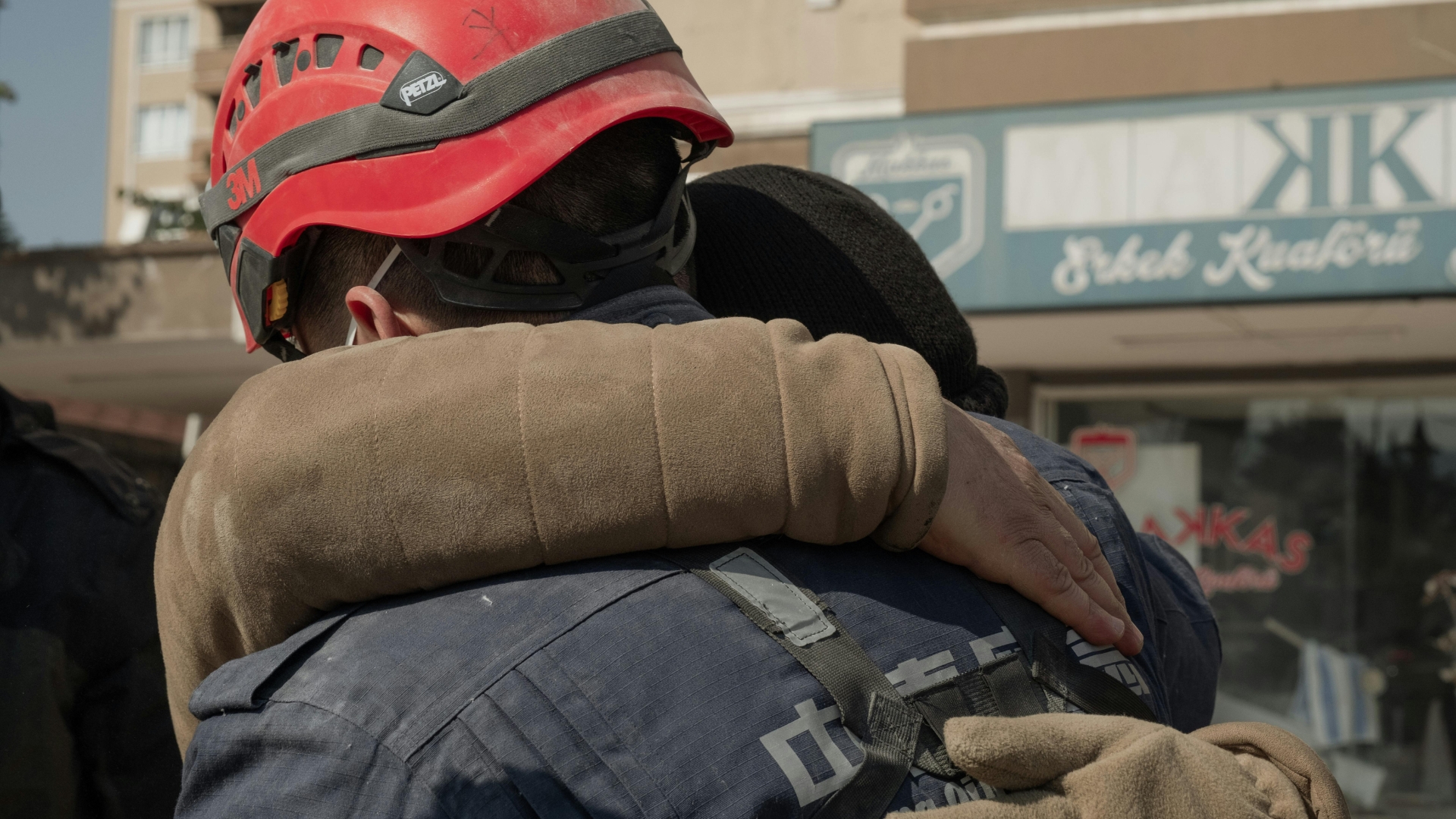 Photograph of person embracing rescue worker after an earthquake.