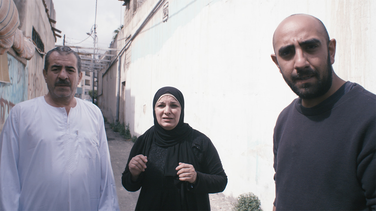 Still from Frontline Humanitarian Toolbox shows local NGO staff chatting with a local man and woman.
