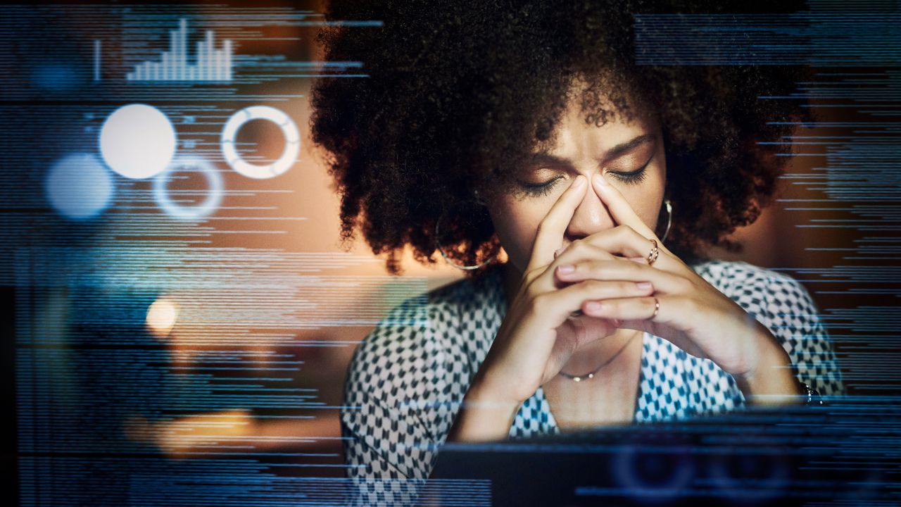 Too much data. Image of exhausted woman at her laptop surrounded by graphics of data. 